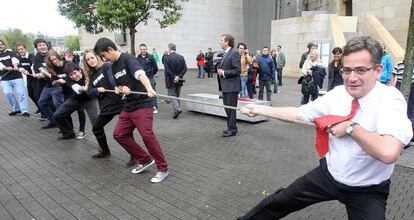Antonio Basagoiti, ayer, en una sokatira en Bilbao contra jóvenes del PP con camisetas con nombres de líderes nacionalistas.