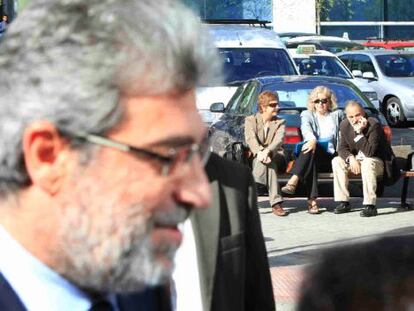 Miguel &Aacute;ngel Rodr&iacute;guez camina cerca de la Audiencia de Madrid ante la mirada de Luis Montes, sentado en un banco, el pasado abril.