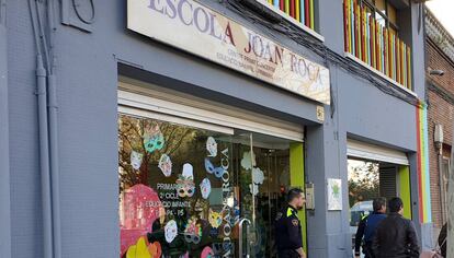 Una pareja de policías sale de la Escola Joan Roca.