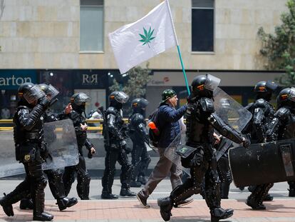 Un manifestante por la legalización del cannabis rodeado de policías, en septiembre de 2018, en Bogotá.