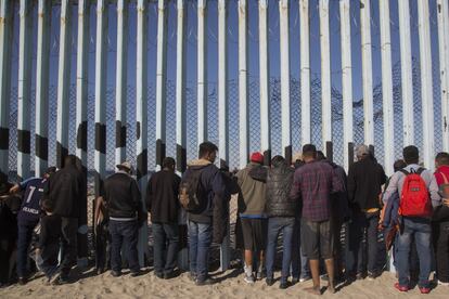 Um grupo de migrantes na zona de Playas de Tijuana. Do outro lado da cerca está San Diego (Califórnia).