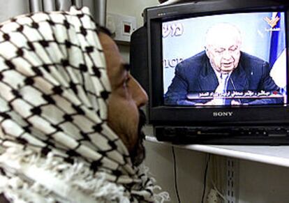 Un palestino observa la intervención en la que Sharon vertió duras acusaciones contra el presidente Arafat.