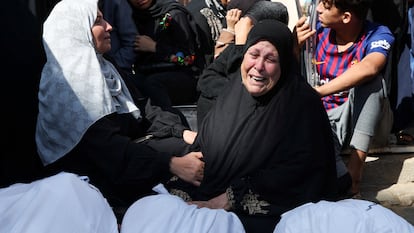 Una mujer llora ante varios cadáveres tras un ataque israelí. 