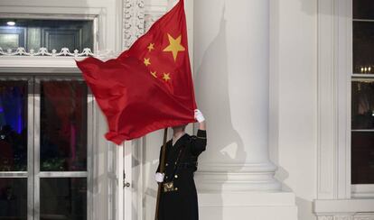 Un militar sostiene una bandera china en la Casa Blanca, en Washington, en 2011 por la visita del entonces presidente chino, Hu Jintao.