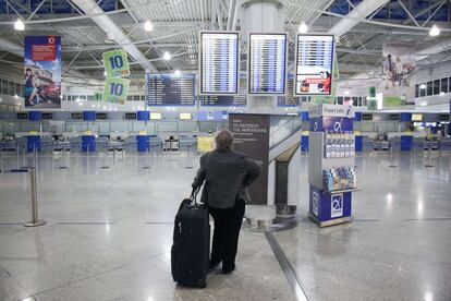 Un pasajero mira la información de los vuelos en el aeropuerto internacional de Atenas, durante la huelga general de 48 horas.