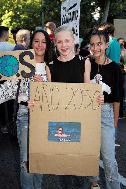 Tres de las participantes con una pancarta que le hace un guiño a Titanic.