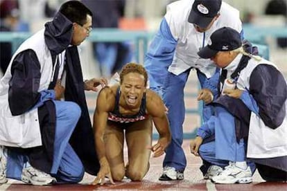 <b>LA CAMPEONA OLÍMPICA, POR LOS SUELOS. </b>Miembros de la organización de Helsinki '05 consuelan a la atleta Joana Hayes, tras caerse al tropezar con una valla.