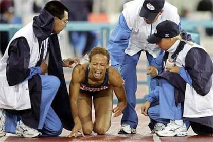 <b>LA CAMPEONA OLÍMPICA, POR LOS SUELOS. </b>Miembros de la organización de Helsinki &#39;05 consuelan a la atleta Joana Hayes, tras caerse al tropezar con una valla.