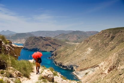 anuncia la llegada a la cala homónima (en la foto), enclave repoblado desde hace decenios por una comunidad alternativa instalada en rehabilitadas moradas de piedra, tiendas de campaña e incluso cuevas. Una mezcla de rastafaris, perros y paneles solares, más un par de chiringuitos muy rústicos que venden bebidas, bocadillos y pizzas (cuando deciden abrir). El camino de Las Negras a Agua Amarga (13 kilómetros) se cubre en unas cuatro horas, y es de dificultad moderada. Eso sí, la sombra escasea.