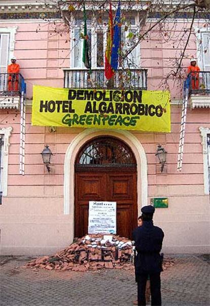 Un policía de vigilancia de la Casa Rosa observa a los ecologistas encaramados en los balcones.