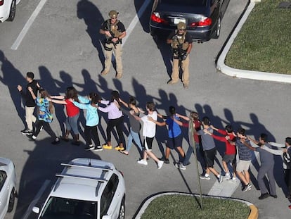 Alumnos del instituto de Parkland son escoltados por un soldado, febrero de 2018.