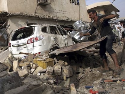 Un hombre quita escombros tras la explosi&oacute;n de un coche bomba en el barrio de Karada, en Bagdad, el pasado martes.