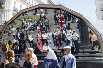 Reflejo de varias mujeres vestidas de chulapas durante la festividad de San Isidro, patrón de Madrid, en la puerta del Sol.