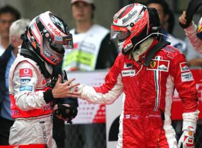 Alonso, a la izquierda, felicita a Raikkonen tras su triunfo en China.