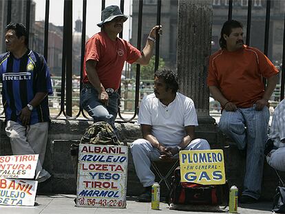 Albañiles mexicanos ofrecen sus servicios en una calle de la capital.