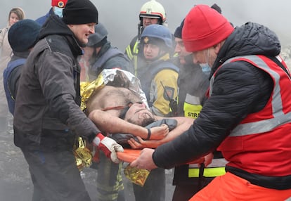 Rescuers carry a local resident at the site of a residential building heavily damaged during a Russian missile attack.