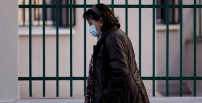 Una mujer con mascarilla camina en una calle de Madrid.