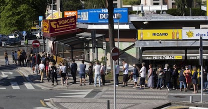 Dozens of people line up to buy cigarettes and alcohol in Behobia, Irún on Sunday.