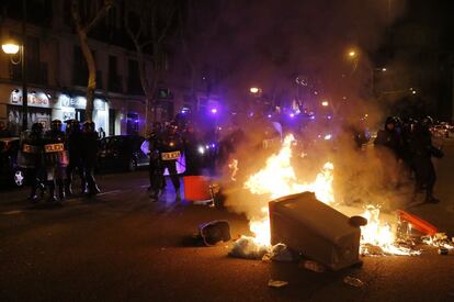 Antidisturbios de la Polic&iacute;a junto a los cubos de basura quemados en el Paseo de Delicias de Madrid, tras las manifestaciones convocadas por la &#039;Marea Ciudadana&#039;