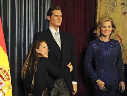 Una mujer posa con las figuras de Iñaki Urdangarin y la infanta Cristina en el Museo de Cera de Madrid.