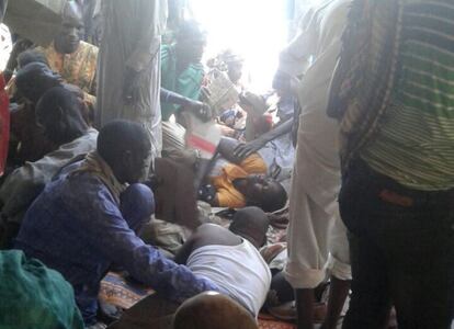 Personas lesionadas son consoladas tras el bombardeo del campamento para personas desplazadas en Rann (Nigeria).