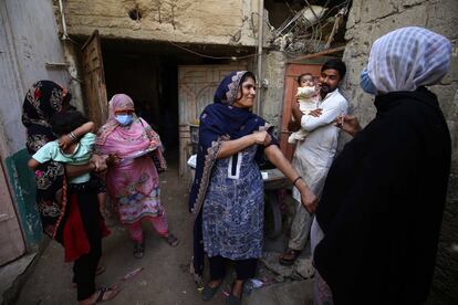 Una trabajadora de la salud inocula una vacuna contra la covid durante una campaña de inmunización de puerta a puerta lanzada por el Gobierno, en Karachi (Pakistán). El objetivo es administrar más de 35 millones de vacunas anticovid, en un intento de vencer la resistencia de las personas a vacunarse.