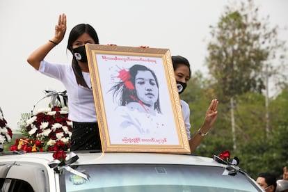 Varias mujeres sostienen un retrato de Mya Thwate Thwate Khaing, una manifestante muerta por disparos de la policía durante las protestas en Myanmar, en la comitiva del funeral por la joven el 21 de febrero.