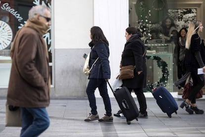 Dos turistas se dirigen a un piso tur&iacute;stico en el centro de la capital.