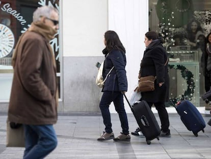 Dos turistas se dirigen a un piso tur&iacute;stico en el centro de la capital.