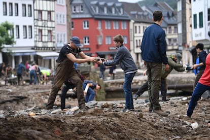 Unas personas recogen escombros en la zona peatonal de Bad Muenstereifel, en el oeste de Alemania.