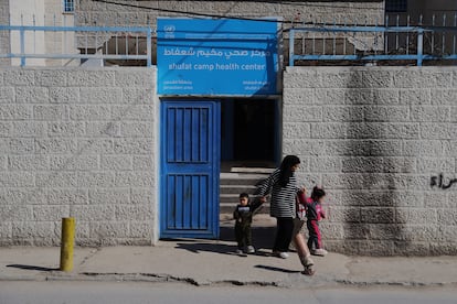 Una madre sale junto a dos de sus hijos del centro de salud del campo de refugiados de Shuafat, en Jerusaln Este, que depende de la agencia de la ONU para los refugiados palestinos (UNRWA).