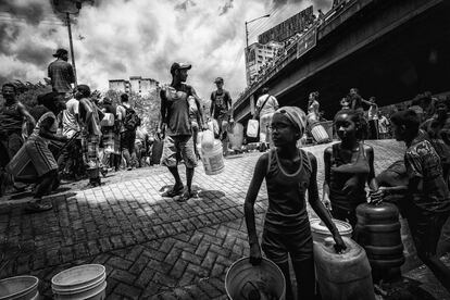 Vizinhos do bairro San Martín são vigiados pela Policial Nacional Bolivariana depois de coletar água de um riacho natural em Caracas, no dia 11 de março de 2019. A Venezuela entrou em uma forte crise de fornecimentos, e a escassez de água, eletricidade e comida levou a situação a um ponto crítico.