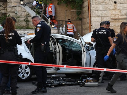 La policía israelí, junto al coche utilizado este lunes por dos atacantes en Jerusalén.