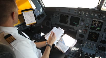 Un piloto de Iberia repasa la documentaci&oacute;n de la cartera de vuelo, actualmente digitalizada. Pablo Monge