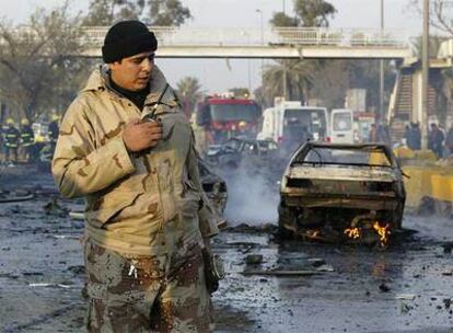 Un soldado iraquí vigila la zona donde ayer explotó un coche bomba, cerca de una universidad en Bagdad.