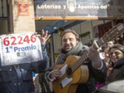 Vecinos de San Lucar la Mayor (Sevilla) el 22 de diciembre de 2013 junto a la administraci&oacute;n de loteria del pueblo.