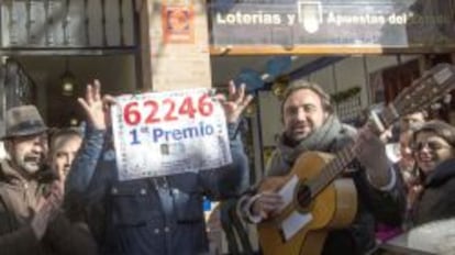 Vecinos de San Lucar la Mayor (Sevilla) el 22 de diciembre de 2013 junto a la administraci&oacute;n de loteria del pueblo.