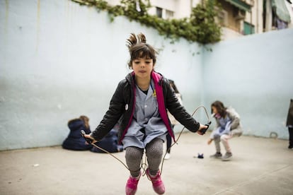 Cora salta a la comba en el recreo en su colegio.