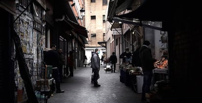 Un hombre espera su turno en una frutería del Mercado de Antón Martín en Madrid. 