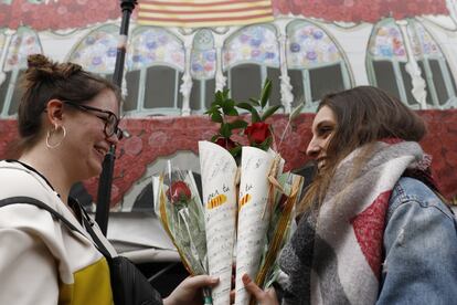 Dues joves intercanvien roses durant el dia de Sant Jordi davant de la Casa Batlló.