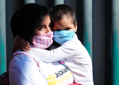 Una madre carga a su hijos enfermo de cáncer en Ciudad de México.