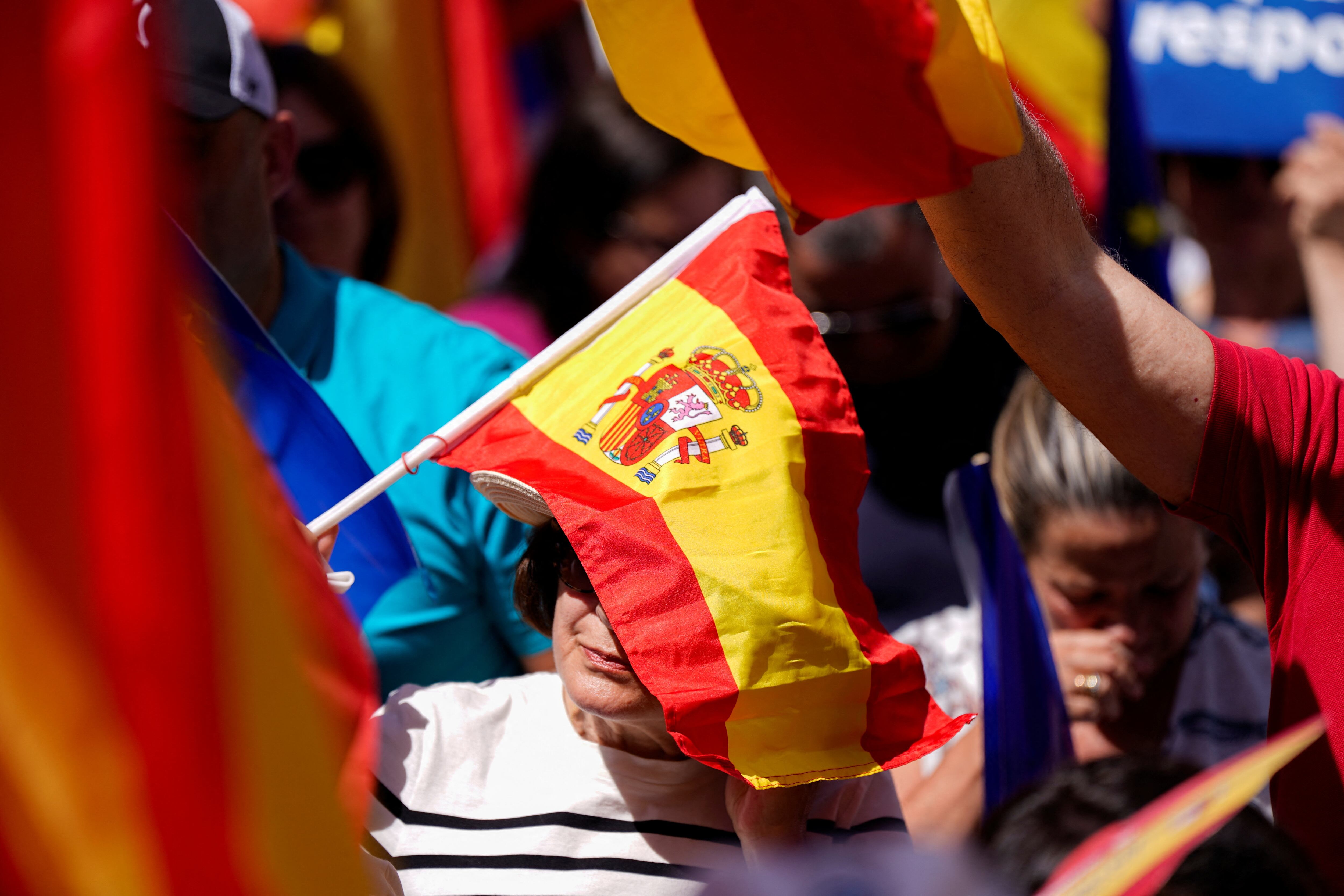 Manifestantes asisten a la concentración convocada por el Partido Popular en la plaza de la Independencia de Madrid, este domingo.  