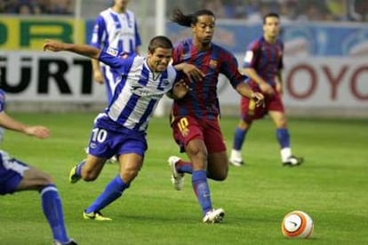 De Lucas se apoya en Ronaldinho mientras ambos corren tras la pelota.