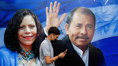 Un hombre revisa su teléfono frente a una pancarta que promueve al presidente nicaragüense Daniel Ortega y a la vicepresidenta Rosario Murillo el 25 de septiembre de 2021.