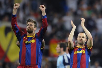 Iniesta y Piqué saludan a los aficionados del Barcelona presentes en el Bernabéu. Con el empate a uno final el equipo de Guardiola mantiene sus ocho puntos de ventaja a falta de seis jornadas para finalizar la Liga.