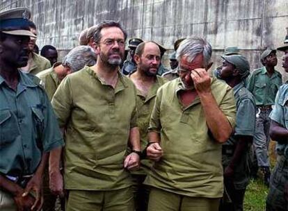 Simon Mann (a la izquierda, en primer plano), con otros compañeros de aventura, tras comparecer en 2004 ante un tribunal de Zimbabue.
Foto: AFP