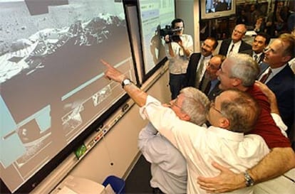 Varios centenares de personas seguían en directo las operaciones en la sala de control del Jet Propulsion Laboratory (JPL), en California, estallaron en un grito de júbilo tras conocer que la maniobra se había efectuado correctamente. En la imagen, el director de la NASA, Sean O'Keefe, abraza a sus colegas.