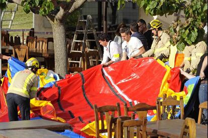 Operarios y bomberos retirando el castillo hinchable.