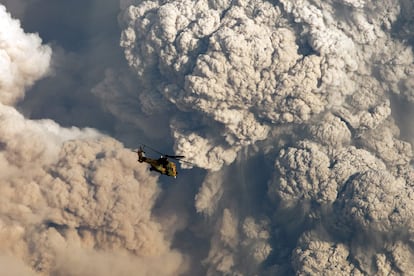 Un helicóptero militar vuela frente la columna de humo provocada por una explosión en el complejo volcánico Puyehue - Cordón Caulle en Riñinahu. El volcán redujo su actividad tras las primeras horas (imagen tomada el domingo 5 de junio).