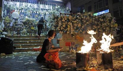 Una mujer quema dinero en señal de respeto a los manifestantes que resultaron heridos frente a la estación Prince Edward, este viernes en Hong Kong.